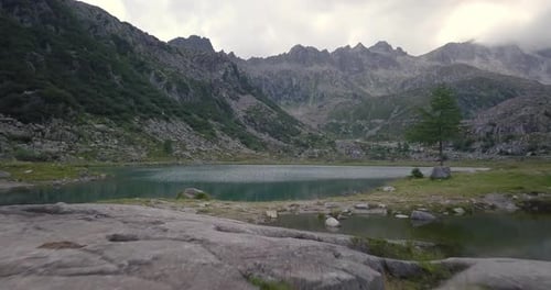 Aerial shot of an lake of mountains surrounded by nature in a magical, relaxing and green place.
