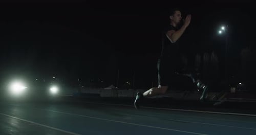 Determined Athlete with Prosthetic Leg Sprints at Night