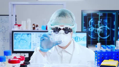 Focused Scientist Examining Petri Dish in Laboratory