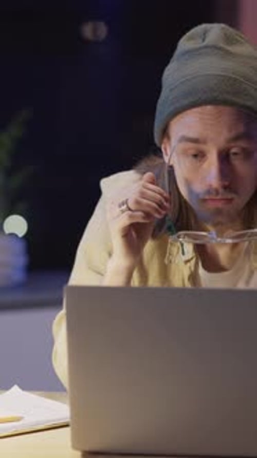 Un homme en bonnet travaille intensément sur son ordinateur portable pour montrer sa concentration