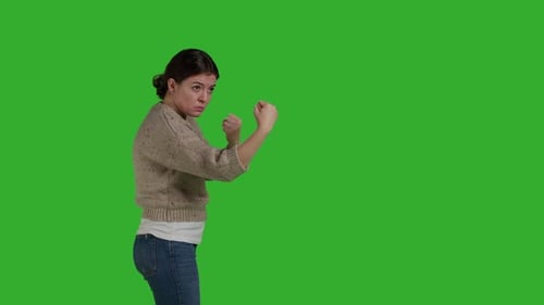 Side View of Aggressive Woman Showing Clenched Fists in Studio