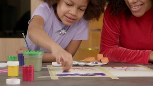 Closeup of Happy School Age African American Girl Sponge Painting Picture