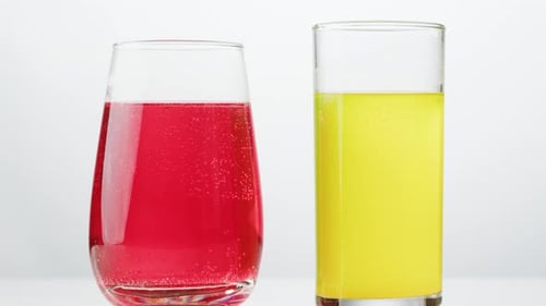 Two Glasses with Red and Yellow Fizzy Drinks