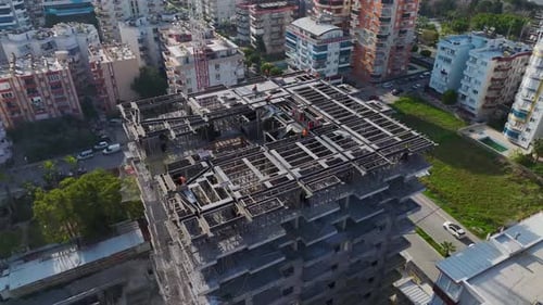 Aerial Video Skyscraper Construction in Progress Workers Install Beams and Reinforcements on the Top
