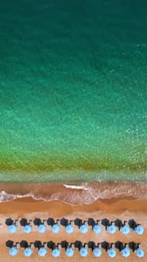 Topdown View of Sandy Beach with Sun Umbrellas and Turquoise Sea Water