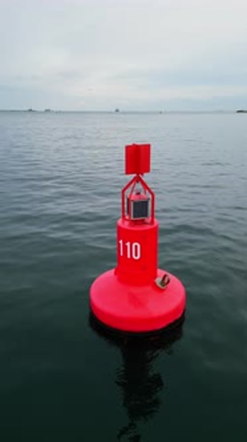 Closeup Aerial View of a Red Navigation Buoy Floating in the Calm Waters of the Sea The Buoy Ensures