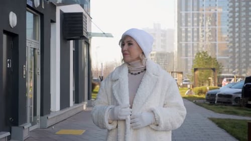 Woman in White Outfit Standing on City Street