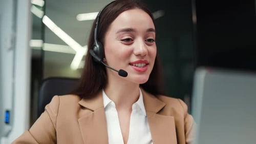 Smiling Woman Teleconferencing in Modern Office Setting
