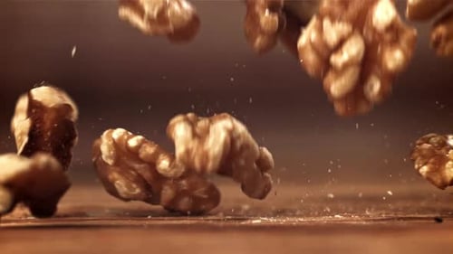Walnuts Falling in Slow Motion on Wooden Surface