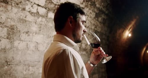 Adult Man Tasting Wine in an Old Cellar