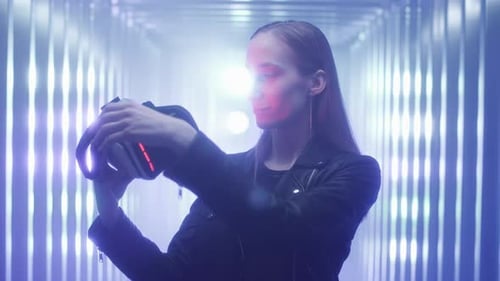 Woman Puts on VR Headset in Blue Corridor