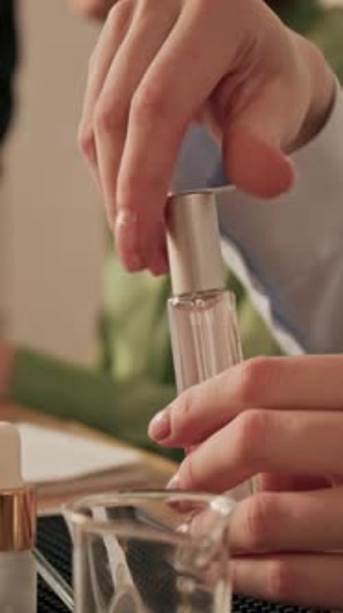 Woman Screwing Cap on Perfume Bottle during Cosmetics Master Class
