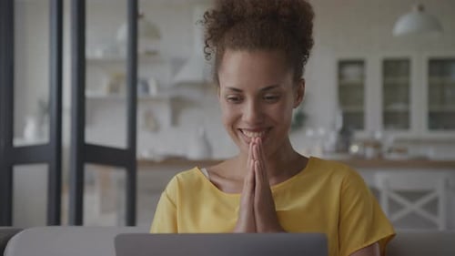 Close Up of an African American Woman Recieving Good News Celebrating Achievement on Her Laptop