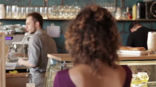 Smiling Barista Serving Coffee to Customer in Cafe