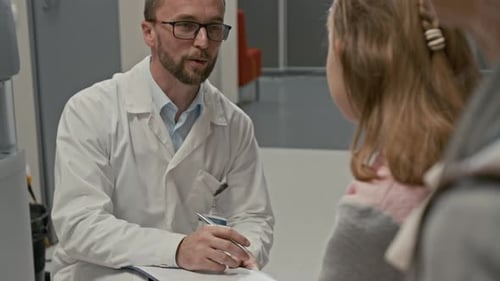 Smiling Doctor Talking to Child in Clinic Hall