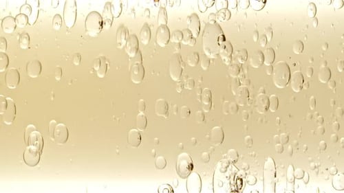 Bubbles Floating in Clear Golden Fluid