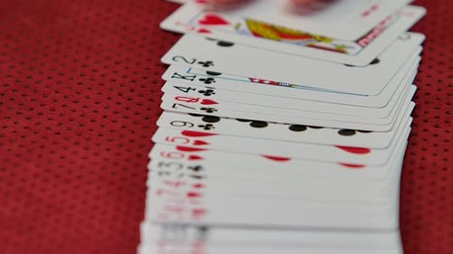 Slow motion shot of a casino dealer spreading a deck of cards.