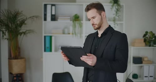 Professional Man Uses Tablet in Modern Office