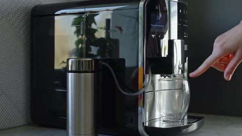 Hand Using Coffee Machine in Kitchen