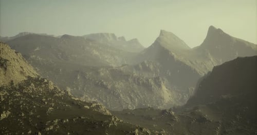 Majestic Mountain Range with Rugged Peaks Under a Soft Sunset Glow