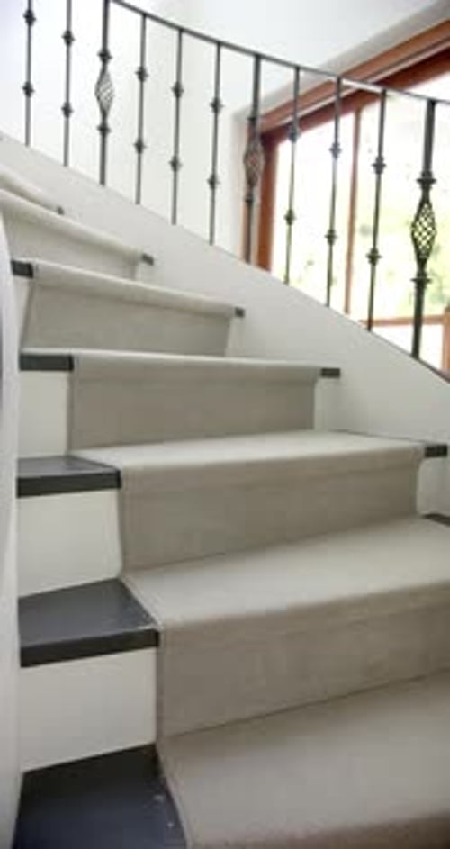 Vertical video of spiral staircase in hallway of luxury home, slow motion