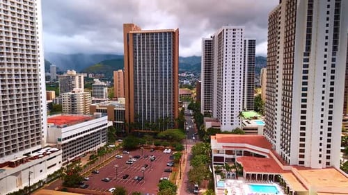 Flight among the high-rise buildings above the parking lot. Honolulu, Oahu, Hawaii, USA.