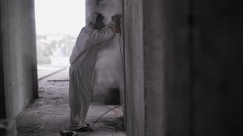 The Builder Polishes the Concrete Dust From Construction Work