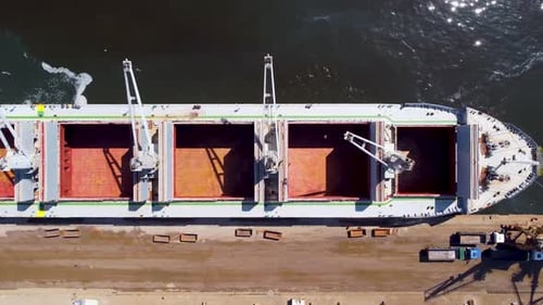 Top Down Aerial View of a Massive Cargo Ship Docked at Port