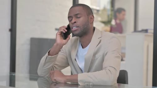 Man Talking on Smartphone in Office Setting