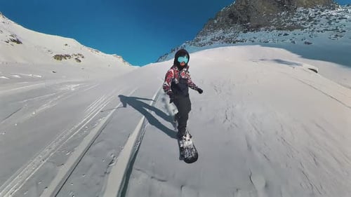 Pov front view of Snowboard freeride. Professional snowboarder ride down the mountain slope at sunny