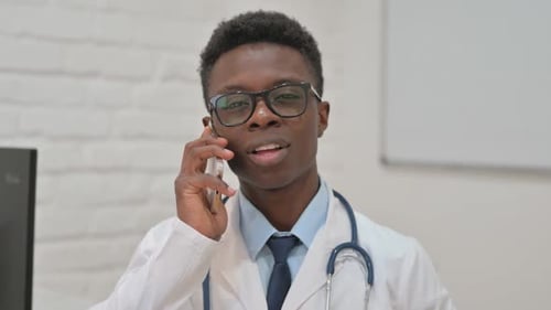 Young Adult Doctor Talking on Phone in Hospital