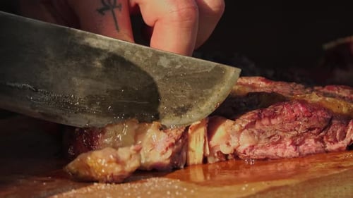 Cutting Grilled Steak on Wood Board, Close Up