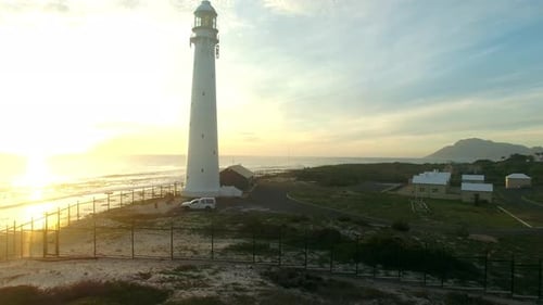 Sunset, drone and ocean with landscape of lighthouse nature, travel beacon and coastal landmark