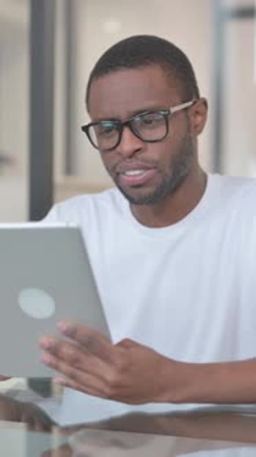 Man Engaged in Video Call on Tablet Indoors