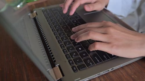 Nahaufnahme der Hände einer Frau, die auf einem Laptop tippt. Das Konzept, überall zu arbeiten und aus der Ferne zu arbeiten.