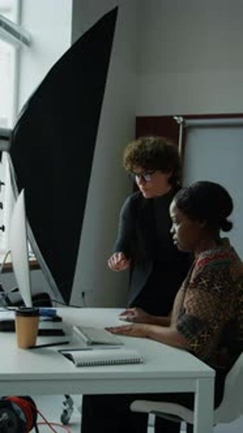 Colleagues Discussing Work at Computer Workstation