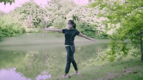 Asian woman exercise in park outdoor with new normal in COVID-19 situation