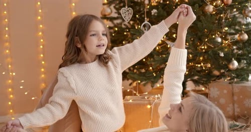 Young Mother with Daugter at Christmas Tree at Home