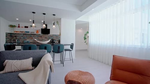 Contemporary Living Space Featuring a Brown Leather Lounge Chair a Woven Ottoman and a Gray Sofa