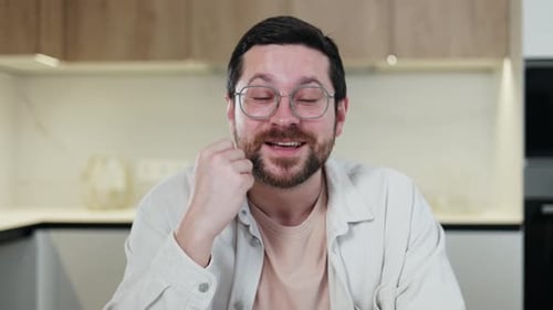 Cheerful Man Talking, Smiling, and Gesturing Indoors