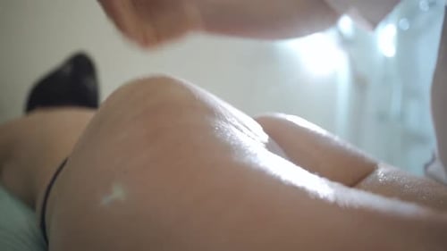 Young woman getting anti-cellulite massage in beauty spa salon. Female massager making body