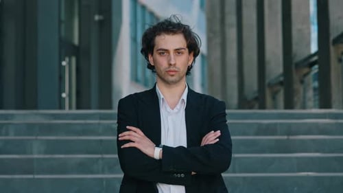 Portrait of the Caucasian Businessman in Formal Suite Standing Near the Business Centre Looking at