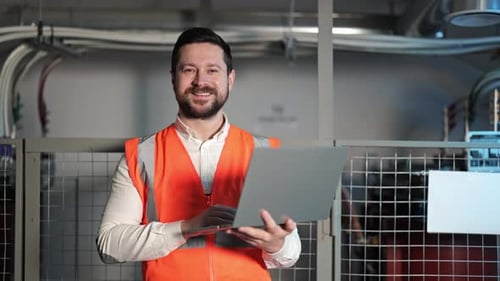 Man with Laptop Smiling in Workplace