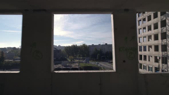 Window view to town buildings from building under construction, flying ...