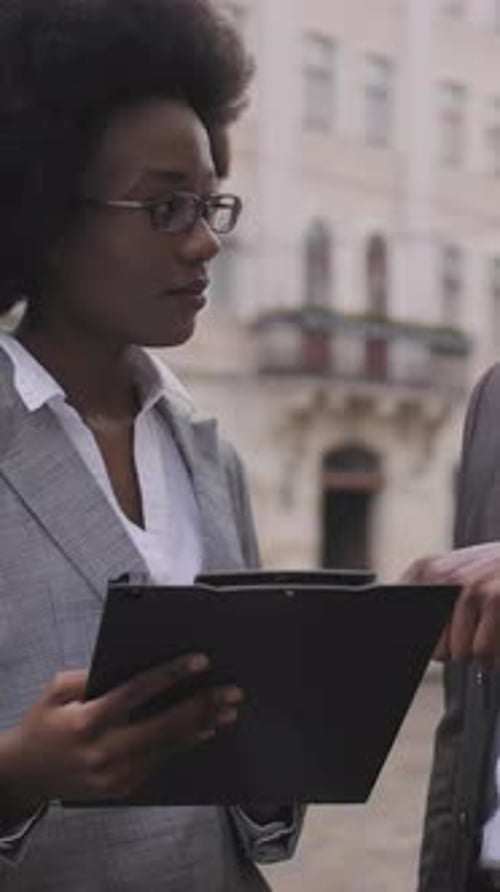 Professionals Discussing Business Plan Using a Tablet in City
