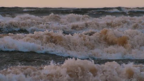 Sea storm with big waves at sunset. Strong waves on the sea coast. Selective focus