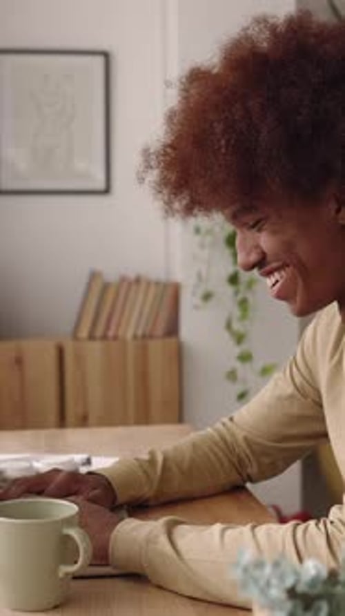 Side View of Young African American Student Man Working on Laptop at Home Studio