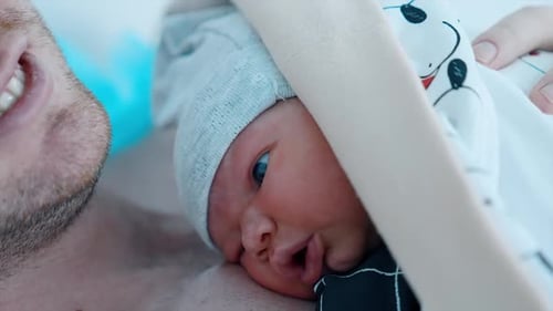 Newborn Baby Resting on Father's Chest Close Up