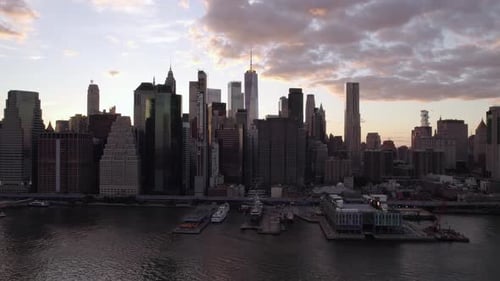 Aerial view in front of the backlit Lower Manhattan cityscape from East river, sunset in NY, USA - t