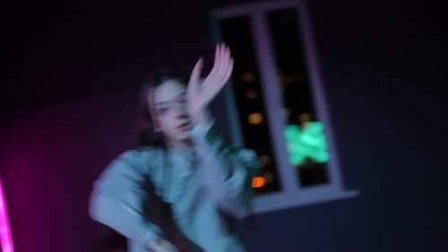 Live Camera A Girl Dancing a Dynamic Modern Dance in a Dark Choreographic Hall with Neon Illuminated